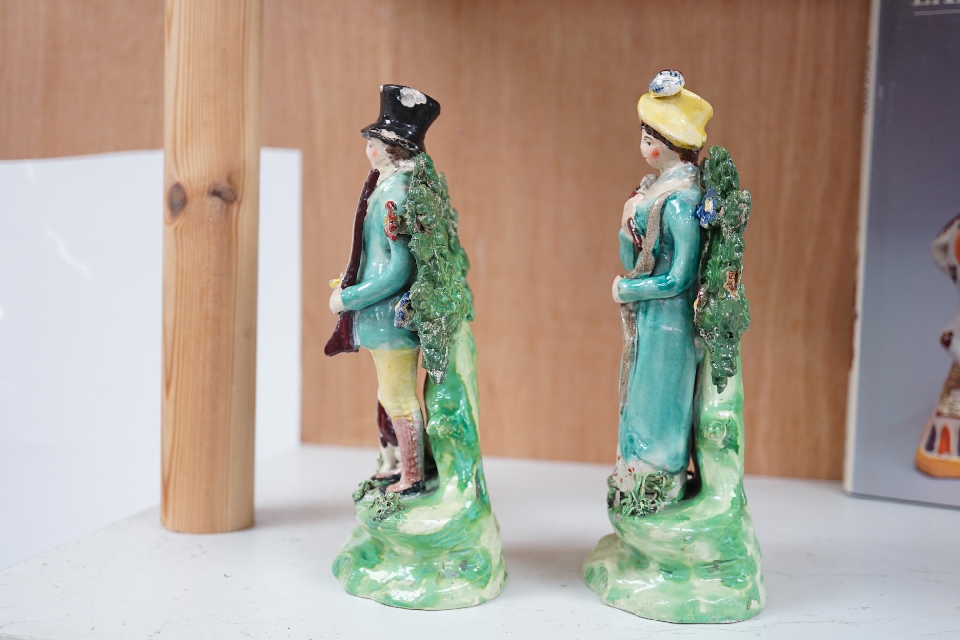 A pair of early 19th century pearlware figures of a huntsman and a female archer, 19.5cm high. Condition - some restoration otherwise in reasonable condition